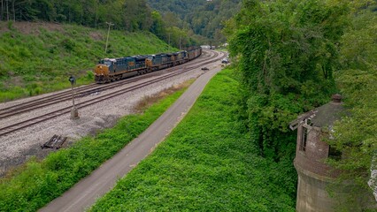 a freight train on the tracks near an old abandoned tower