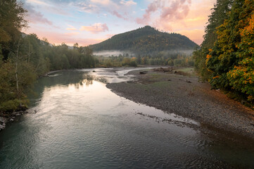 Flowing sunrise river during the autumn season. Morning light highlights the waters edge and the...