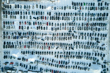 Aerial view of vehicle open market lot with many cars for sale parked and people customers walking in winter