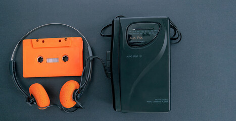 Retro cassette player, Wallman, headphones and an orange cassette tape. 80s and 90s. (1)