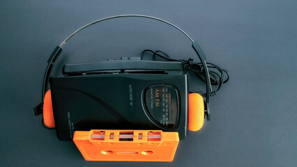 Retro cassette player, Wallman, headphones and an orange cassette tape. 80s and 90s. 3