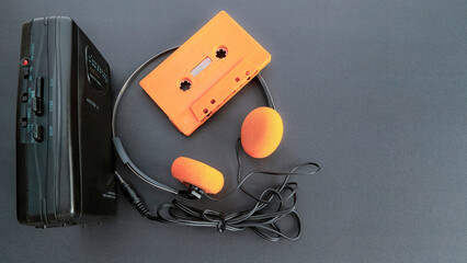 Retro cassette player, Wallman, headphones and an orange cassette tape. 80s and 90s. 4