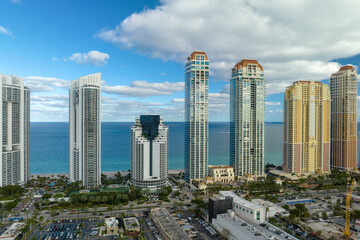 Fototapeta na wymiar High angle view of Sunny Isles Beach city with expensive highrise hotels and condo buildings on Atlantic ocean shore. American tourism infrastructure in coastal southern Florida