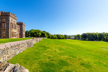 The historic Lews Castle looks out over the harbor port of the village of Stornoway, Scotland, on...