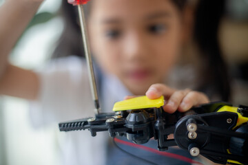 STEM education concept. Asian young girl learning robot design.