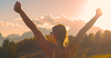 CLOSE UP, LENS FLARE: Victorious moment of a lady reaching beautiful mountaintop - obrazy, fototapety, plakaty