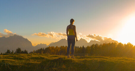 CLOSE UP, LENS FLARE: Sporty woman paused at the top to admire beautiful sunset - obrazy, fototapety, plakaty