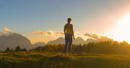 Foto op Canvas CLOSE UP, LENS FLARE: Sporty woman paused at the top to admire beautiful sunset © helivideo