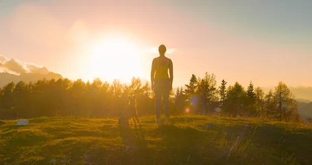 Foto op Aluminium CLOSE UP, LENS FLARE: Lady with a dog admires spectacular sunset at the hilltop © helivideo