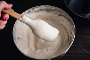Hand Holding a Spatula with Freshly Mixed Angel Food Cake Batter: Egg whites and cake flour folded...