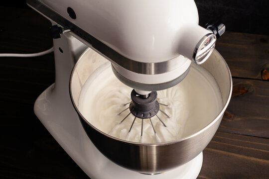 Stand Mixer with a Whisk Attachment in Beaten Egg Whites: Electric mixer in the down position with stiff egg whites in the bowl