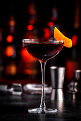 Adonis cocktail drink with sherry and red vermouth, black bar counter background, steel tools and bottles - obrazy, fototapety, plakaty