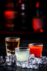Tequila with sangrita and lime juice. Black bar counter background