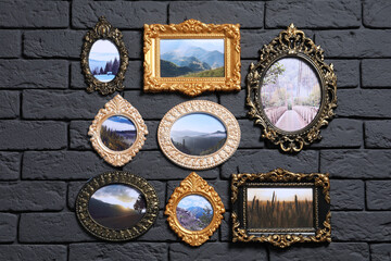 Vintage frames with photos of beautiful landscapes hanging on dark brick wall