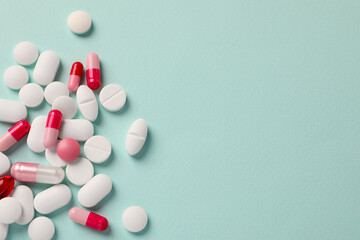 Many different pills on mint background, flat lay. Space for text - obrazy, fototapety, plakaty