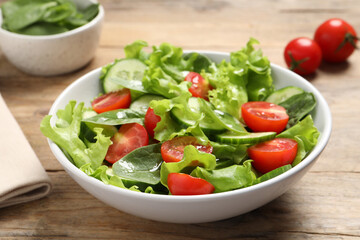 Delicious vegetable salad on wooden table, closeup