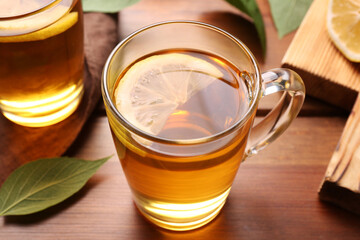 Cups of tasty iced tea with lemon on wooden table, closeup