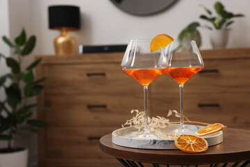 Tasty cocktail in glasses on wooden table in room, space for text. Relax at home