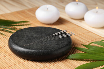 Stone coaster with acupuncture needles on table