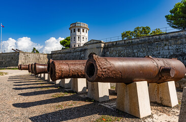 Fototapeta na wymiar Medieval cannon barrels in front of Pula citadel, an artillery fortress with observation tower, Croatia, Europe.