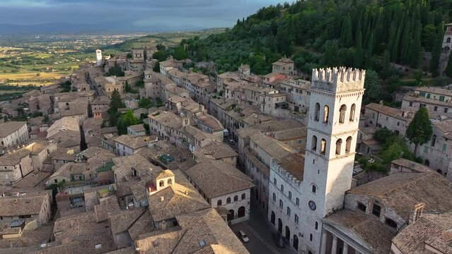 Aerial orbiting shot of Assisi skyline, Torre del Popolo, Piazza del Comune, Santa Maria sopra Minerva Church, summer morning light, Perugia, Umbria, Italy