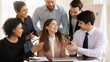 Positive team of multiethnic employees applauding happy excited colleague, congratulating team...