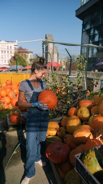 A young female farmer is talking about the cultivation of pumpkins they sell at the market.