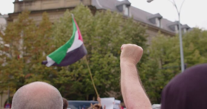 palestine flag fly while a rise fist hold in the air by Israeli-Palestinian Conflict and crisis of gaza