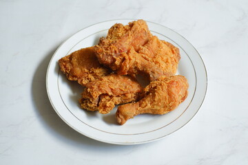 A plate of crispy fried chicken in white background 