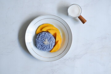 Obraz na płótnie Canvas Top view of a plate of mango sticky rice in white background 