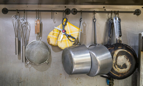 Different cooking utensils hung up on a metal wall in the kitchen of a pizza shop in Monroeville, Pennsylvania, USA