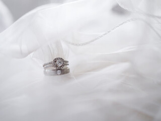 Diamond engagement wedding rings on bridal veil. Wedding accessories, Valentine's day and Wedding day concept.