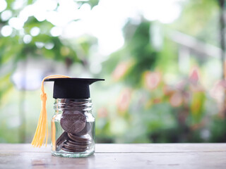 Close up money in the glass bottle with graduation hat. The concept of saving money for education,...