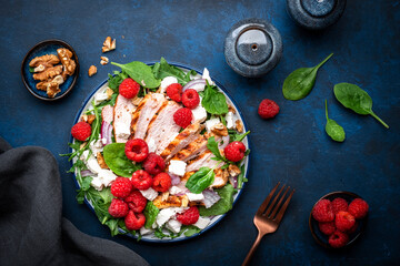 Tasty salad with raspberries, grilled chicken, cheese, onion, walnuts, spinach and arugula, blue...