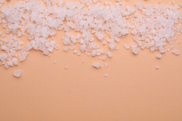 Sea salt on beige background, top view. Space for text