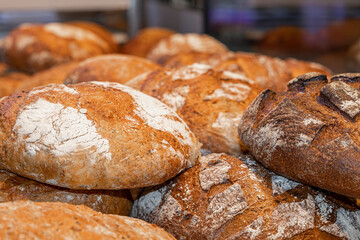 Freshly baked bread on a counter in a bakery, close-up. Bakery products. Sale of bread and loaves