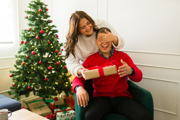 Cheerful couple giving surprise birthday gifts