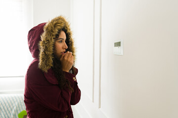 Young woman feeling cold with a broken heating