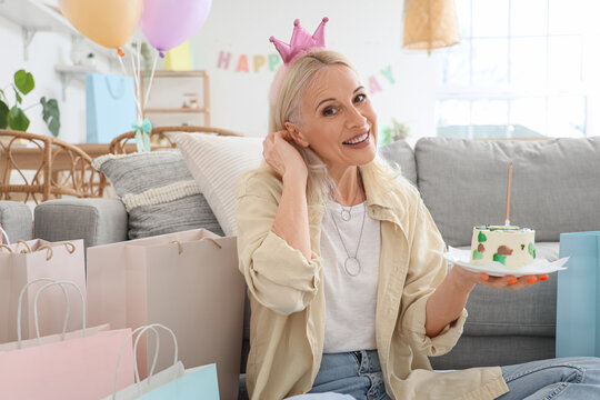 Mature woman with birthday cake at home