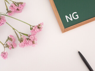 黒板にNGの文字と花とペン、コピースペースあり