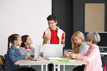 Fototapeta premium Little children studying with devices at school computer lab