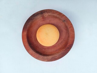 Cookie in a bowl. Small round yellow bread in a wooden bowl isolated on a white background. sweet food. sweet bread.
