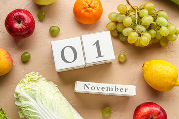 Calendar with date 1 November and different fresh fruits on beige background