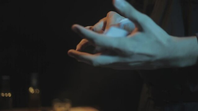 Film-like footage of a magician shuffling cards on a bar table, HD cinema-style footage.