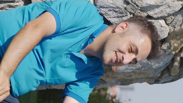 Vertical Video of Outdoors man taking deep breaths with happy expression.