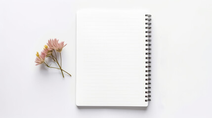 A blank spiral notebook with pink flowers on a white background. This image shows a white notebook with horizontal lines and a bunch of pink and yellow flowers on its left side. The background is