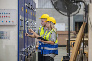 Techs inspecting, maintaining cardboard machine for safety, uninterrupted, high-quality production.