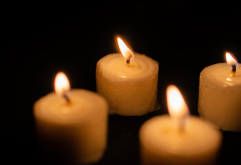 Candles light. Christmas candles burning at night. Abstract candles background. Golden light of...