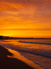 Obraz premium Amazing view of a fiery sunrise with multicolored clouds. Sea waves along the seashore at sunrise. Morning time. Ocean view. La Baule-Escoublac, France
