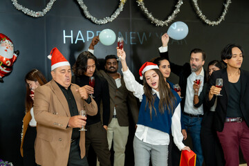 Group of office workers celebrate Christmas and New Year by dancing and drinking wine. Group of international friends and boss dancing with employees.